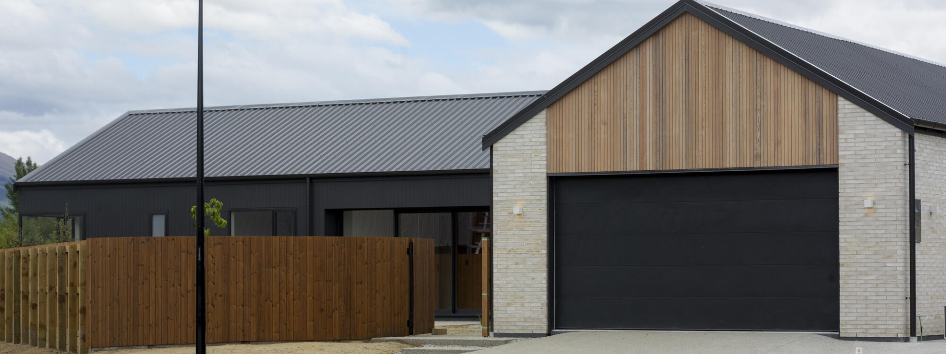 Exterior view of Jack's Point Queenstown Home with Western Red Cedar cladding and TMT Taiga fencing