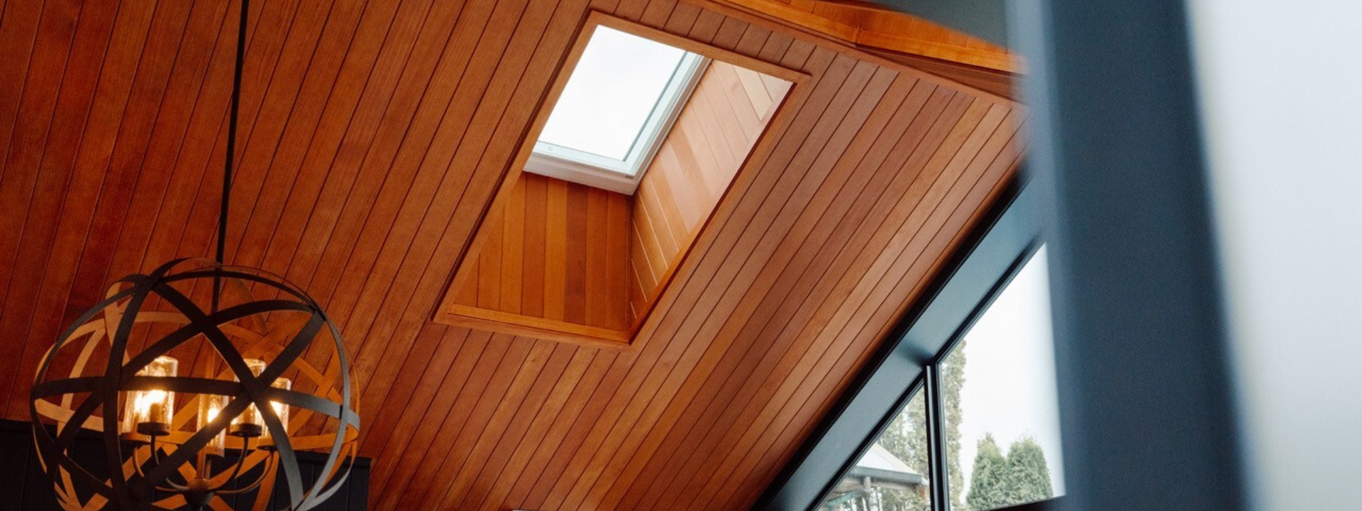 JSC's Alaskan Yellow Cedar ceiling coated in JSC Scumble Desert with light feature contrast against black interior walls by Transform Construction